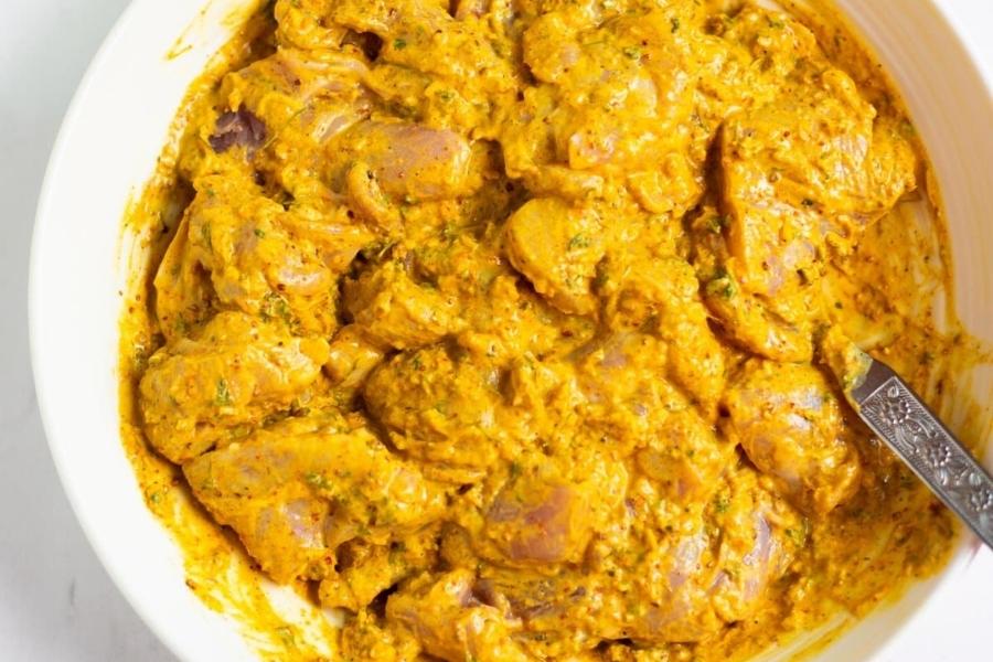 Marinate chicken with yogurt, ginger, garlic paste, salt, chili, and turmeric.