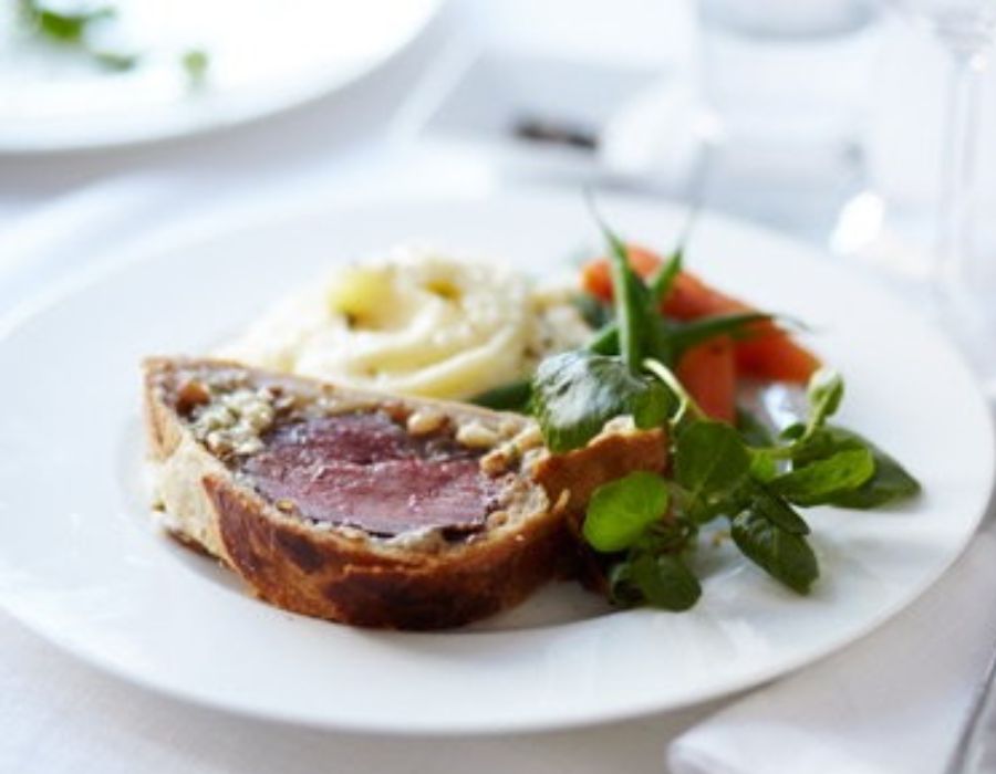 Transfer to a platter, let rest briefly, carve into slices, garnish with parsley, and serve with vegetables.